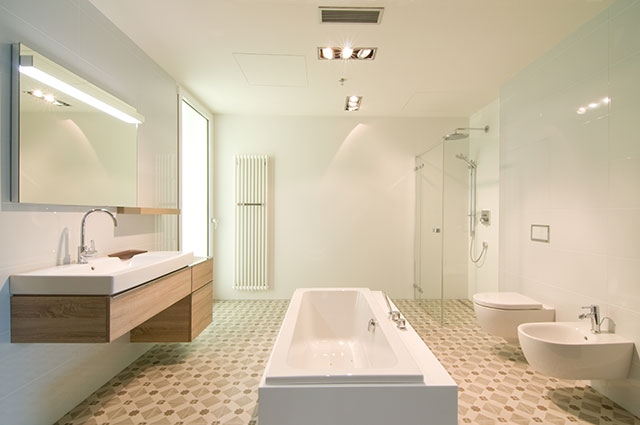 Útulná a prostorná zároveň, koupelna z řady KERAMAG iCon s volně stojící vanou MODO, dřevěným dekorem světlý dub a vkusně zalícovaným tlačítkem Geberit Omega60.


