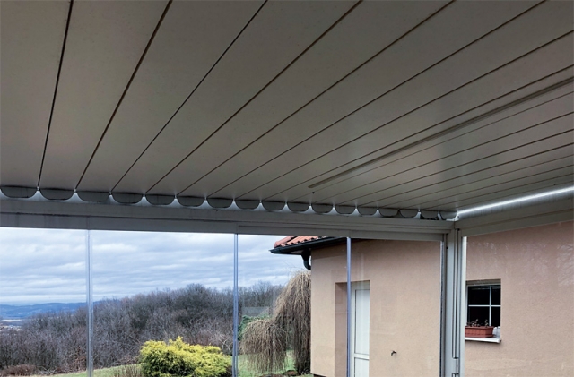 Střecha pergoly je tvořena hliníkovými lamelami, jejichž polohu je možné dle momentální potřeby měnit s pomocí dálkového ovládání a integrovaného elektromotoru až do úplného uzavření střechy. 